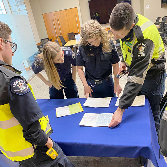 Paramedics around a table reading thank you cards