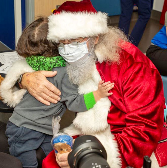 Santa hugging child