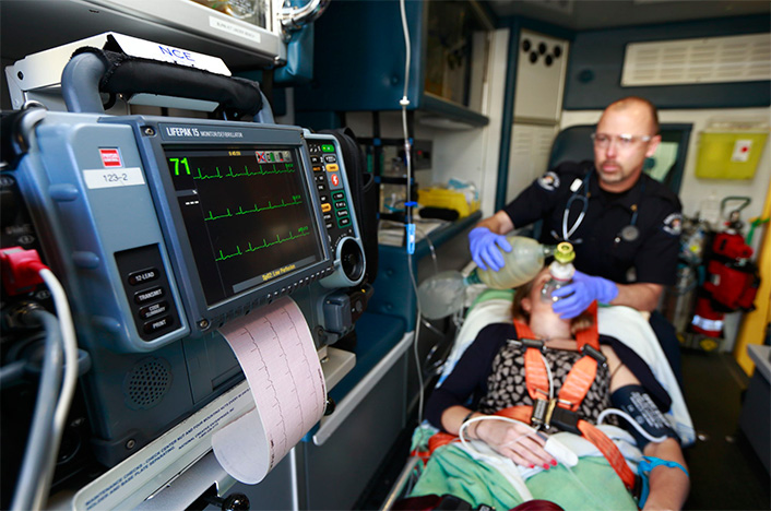Paramedic treating a patient in the back of an ambulance